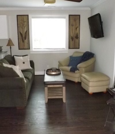 Living room with hardwood floors, crown moldings, storage cabinet