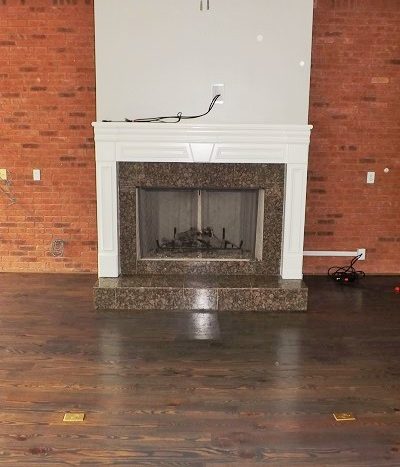 family room with fireplace, exposed brick wall, ceiling fan